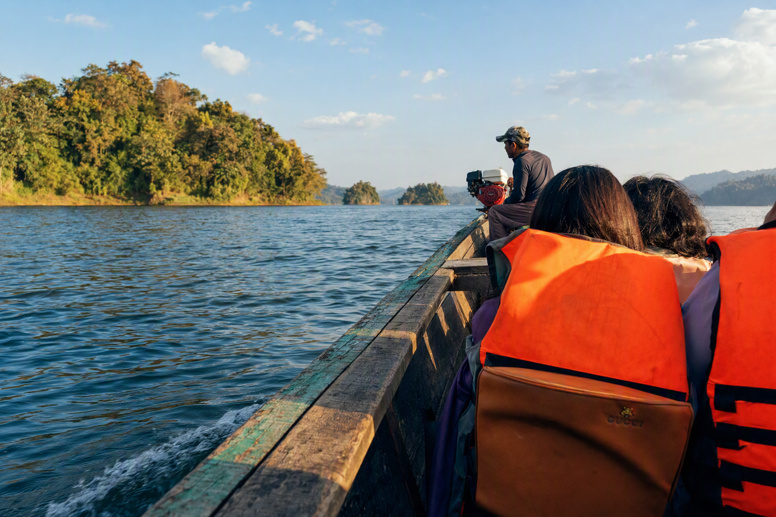A local wooden boat travelling between the forested islands of Kaptai Lake