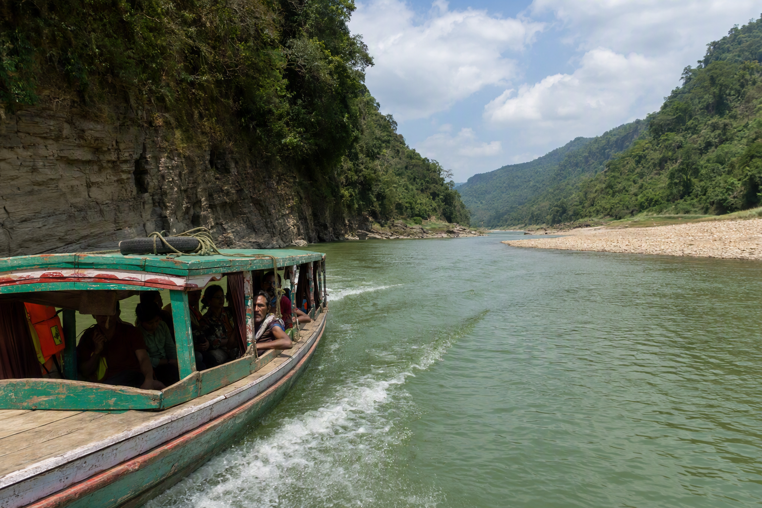 A narrow passenger boat moving along the Sangu River below green hills
