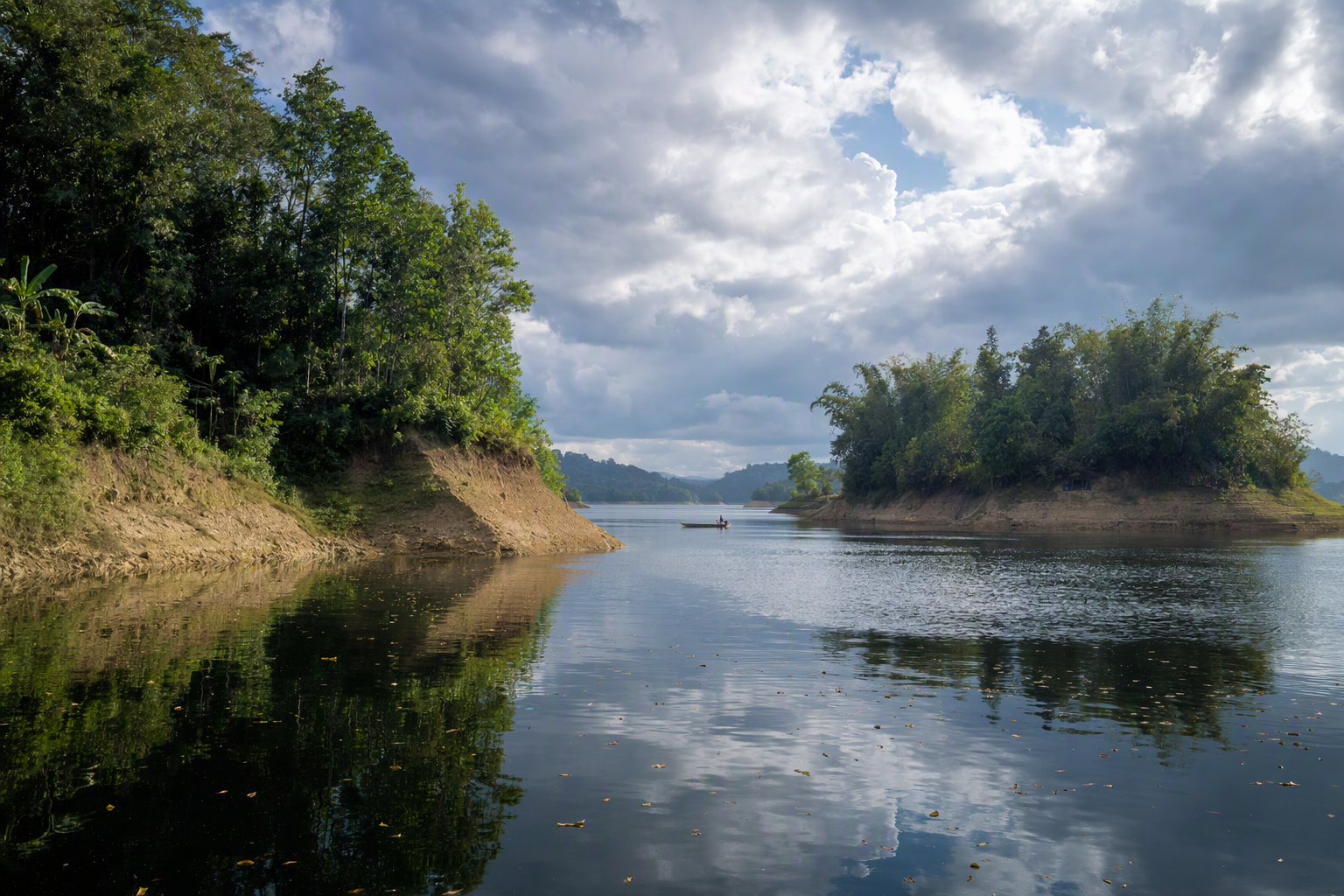 A broad Kaptai Lake channel opening between wooded islands after rain