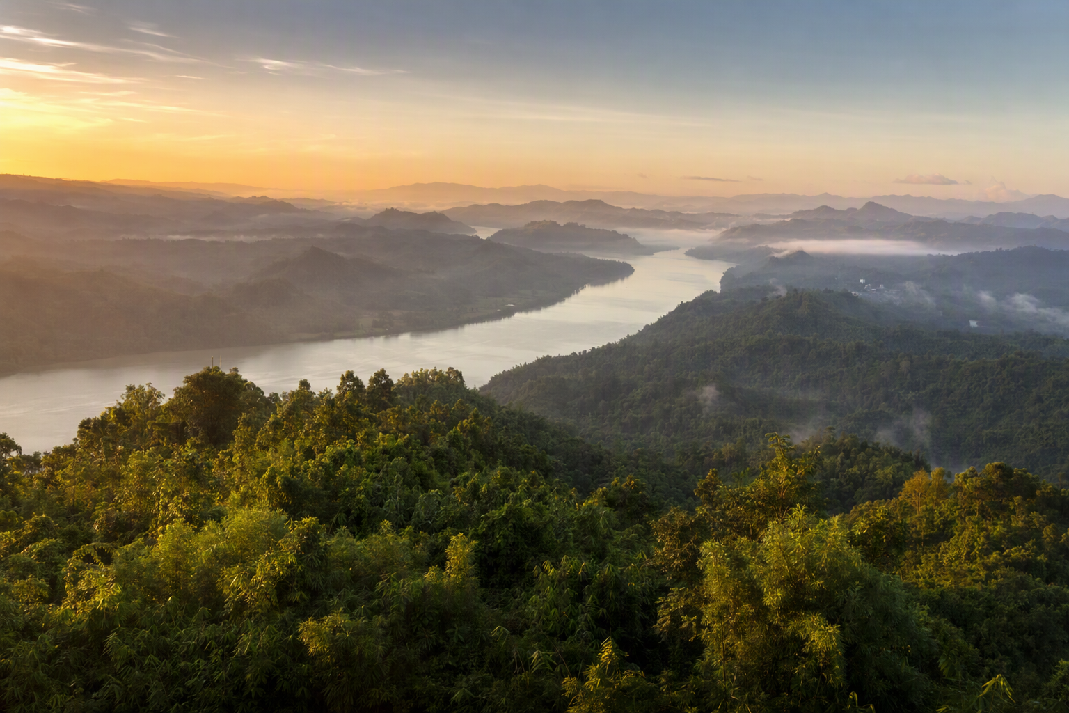 Layered green ridges of the Chittagong Hill Tracts at dawn, with the Karnaphuli River winding through mist